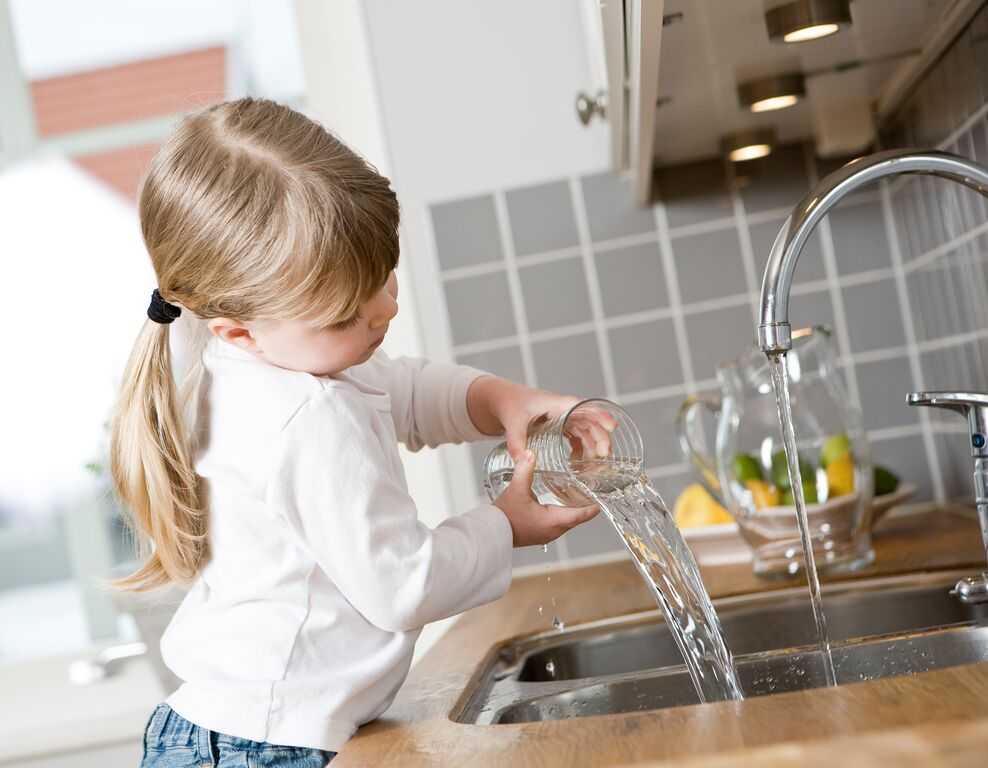 Small Girl in the kitchen drinking water